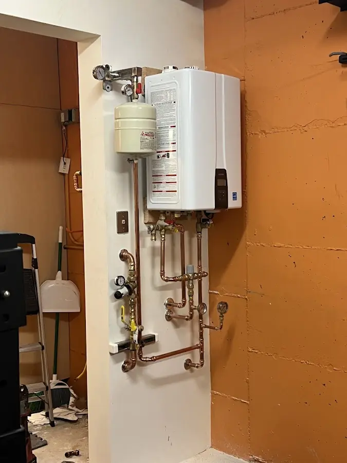 Plumbing technician inspecting water heater connections in Sacramento
